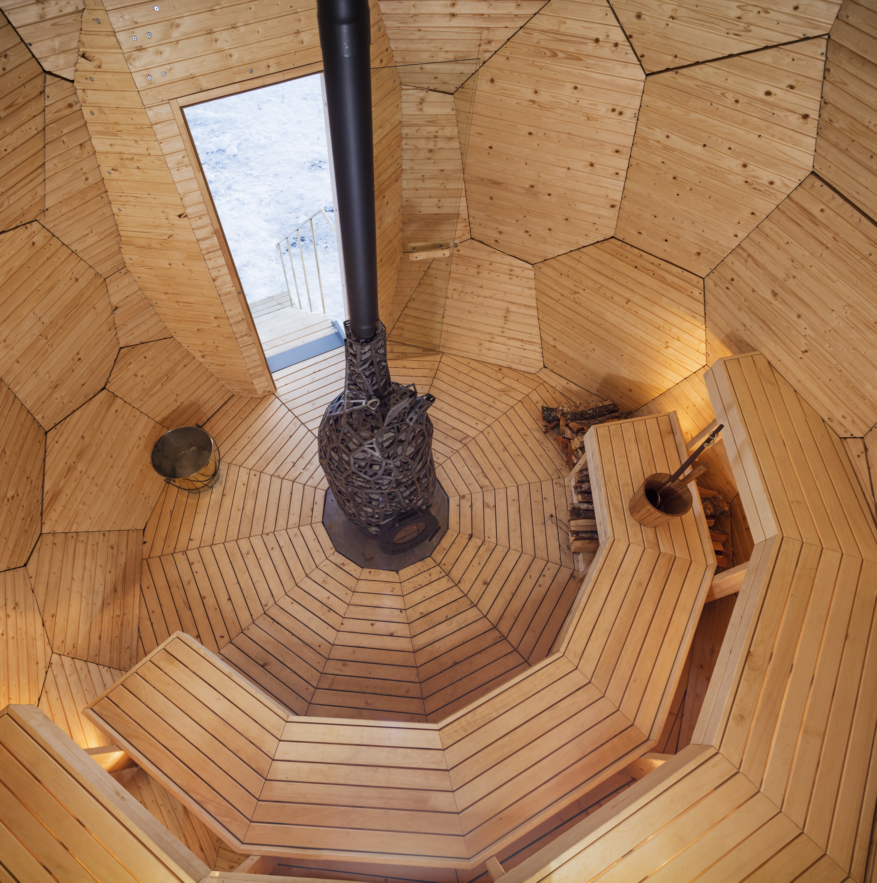 vista general del interior de solar egg con bancos de madera de álamo 