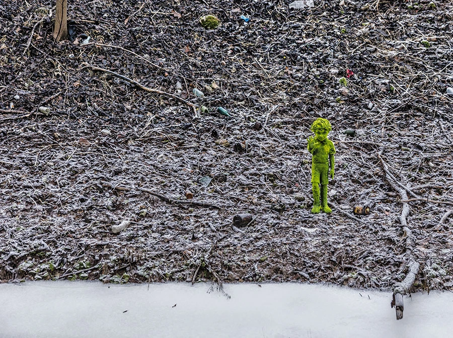 escultura de un niño en el río creada por Kim Simonsson