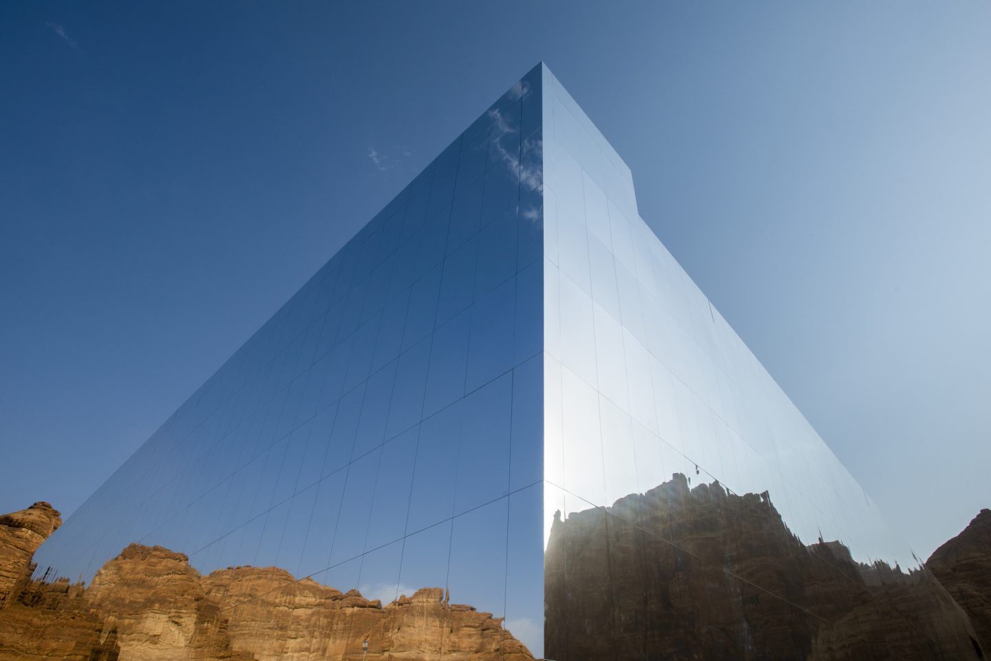 enorme edificio cúbico de 5.000 metros cuadrados cubierto con paneles reflectantes.