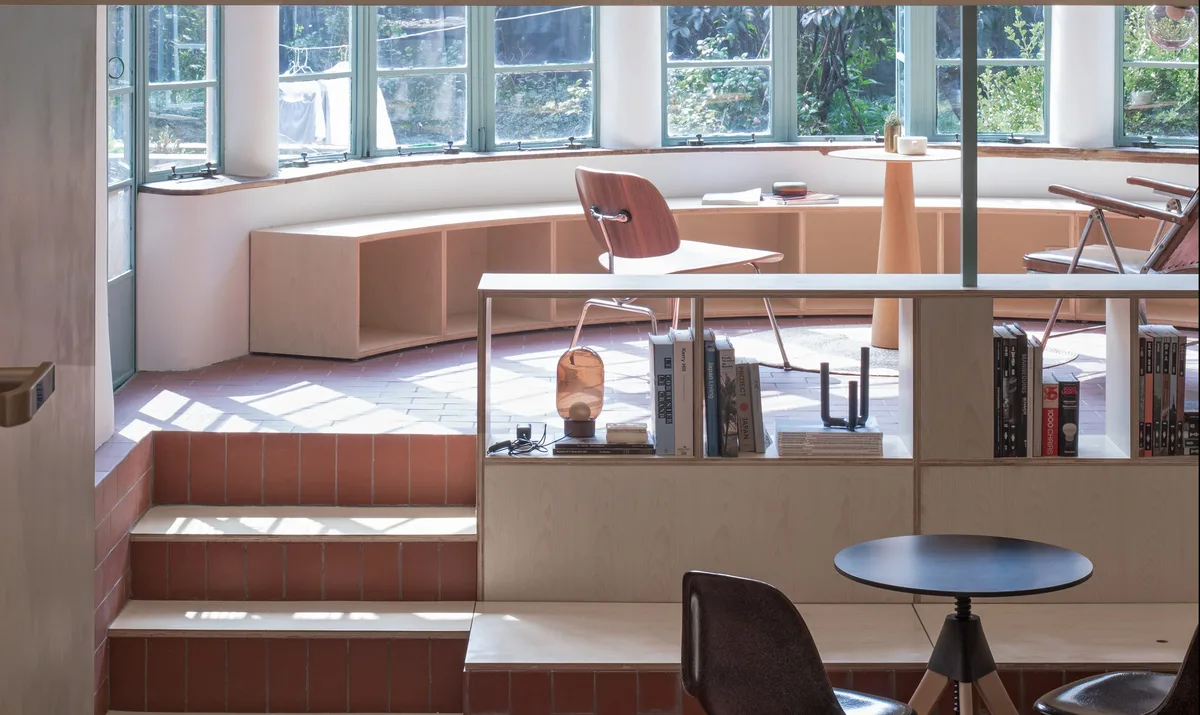 estantería curva que sigue todo el trazado en U del ventanal