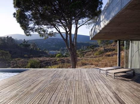piscina Terraza de tarima de madera con vistas a montañas boscosas bajo un pino en la casa búnker de Pedrógão