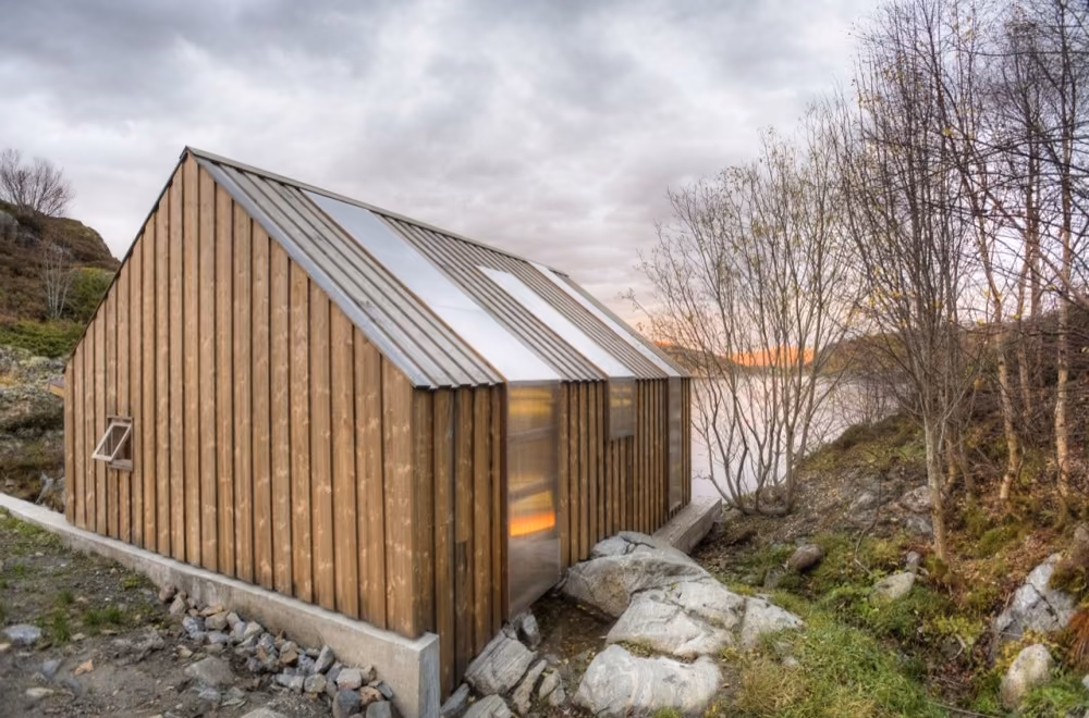 vista general trasera Parte trasera de la casa de pescadores noruega revestida de tablas verticales de pino entre abedules