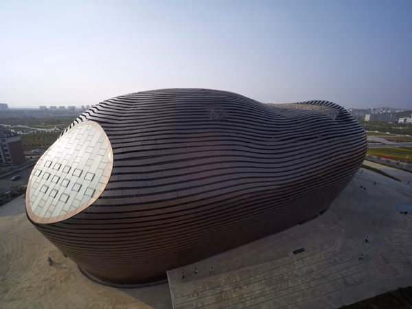 cubiertaordos2 Vista aérea del Museo Ordos, volumen metálico ondulado con un ventanal ovalado en un extremo