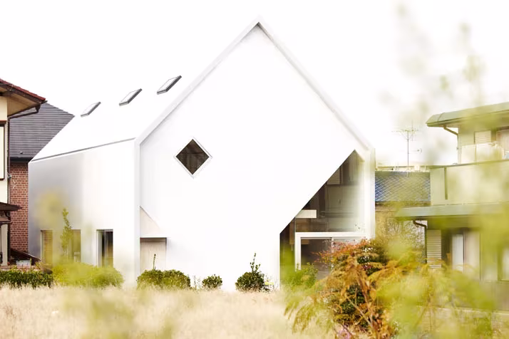 Casa H de Hiroyuki Shinozaki en Tokio, volumen blanco con cubierta a dos aguas, lucernarios y ventana romboidal