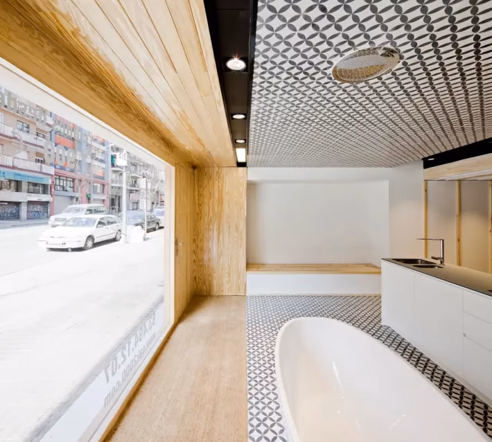 Cocina blanca con bañera exenta y gran ventanal a la calle bajo un techo de baldosa estampada en el Oak Showroom
