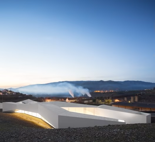 Centro de Alto Rendimiento de Remo de Pocinho de Álvaro Fernandes Andrade al anochecer, con el valle al fondo