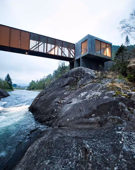 Puente Hose de vigas de acero corten sobre el río, con el volumen de hormigón apoyado en la roca, en Noruega