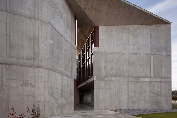 hormigon portugal Volumen de hormigón visto en Portugal con una escalera exterior de madera oscura encajada entre muros