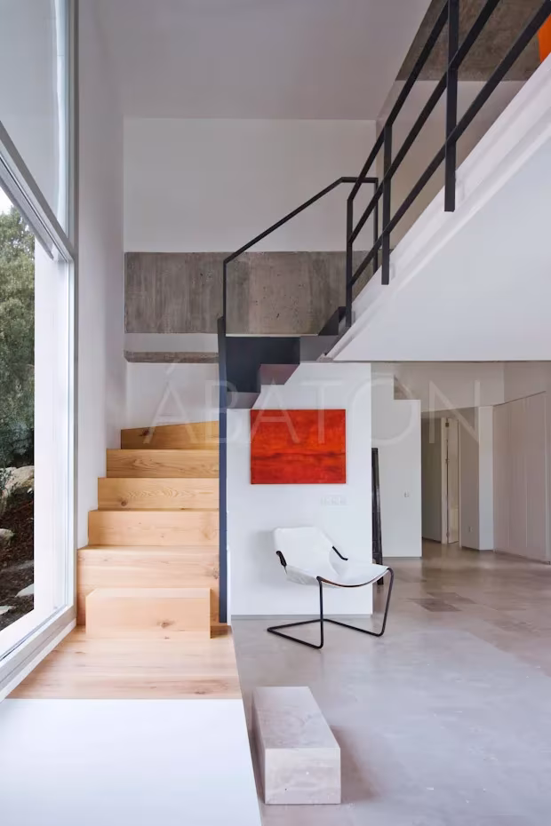 CASA 36-7 Escalera de madera con barandilla metálica y doble altura acristalada en la Casa 36 de Madrid