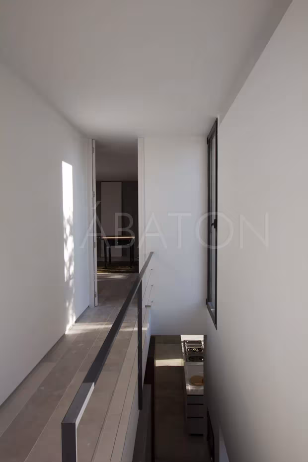 Oficina-7 Pasillo de la oficina-vivienda con barandilla metálica sobre el vacío y suelo de madera clara