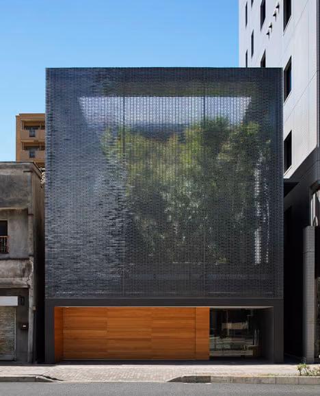 Fachada de bloques de cristal de la Optical Glass House de Hiroshi Nakamura sobre un zócalo de madera, en Hiroshima
