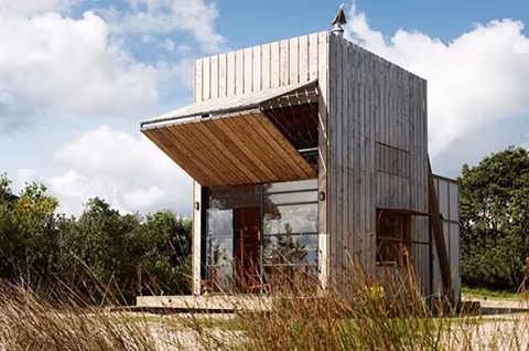 Cabaña de playa transportable de madera de Crosson Clarke Carnachan con su gran portón abatible abierto