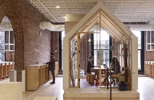 Oficinas de Airbnb en Portland: casetas de madera con forma de casa dentro de una nave de ladrillo