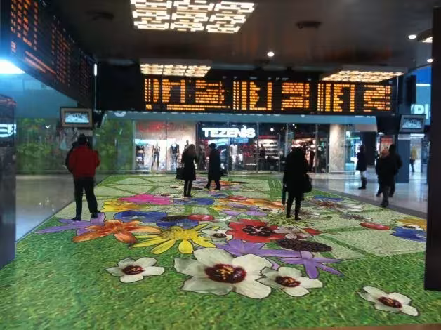 Alfombra de flores de colores sobre el suelo del vestíbulo de la estación de Milán durante el Fuorisalone