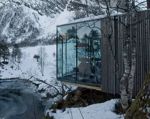 juvet-landscape-hotel-jensen-skodvin-arkitektkontor-01 Volumen de madera con fachada de vidrio reflectante sobre un río helado en el Juvet Landscape Hotel, Noruega