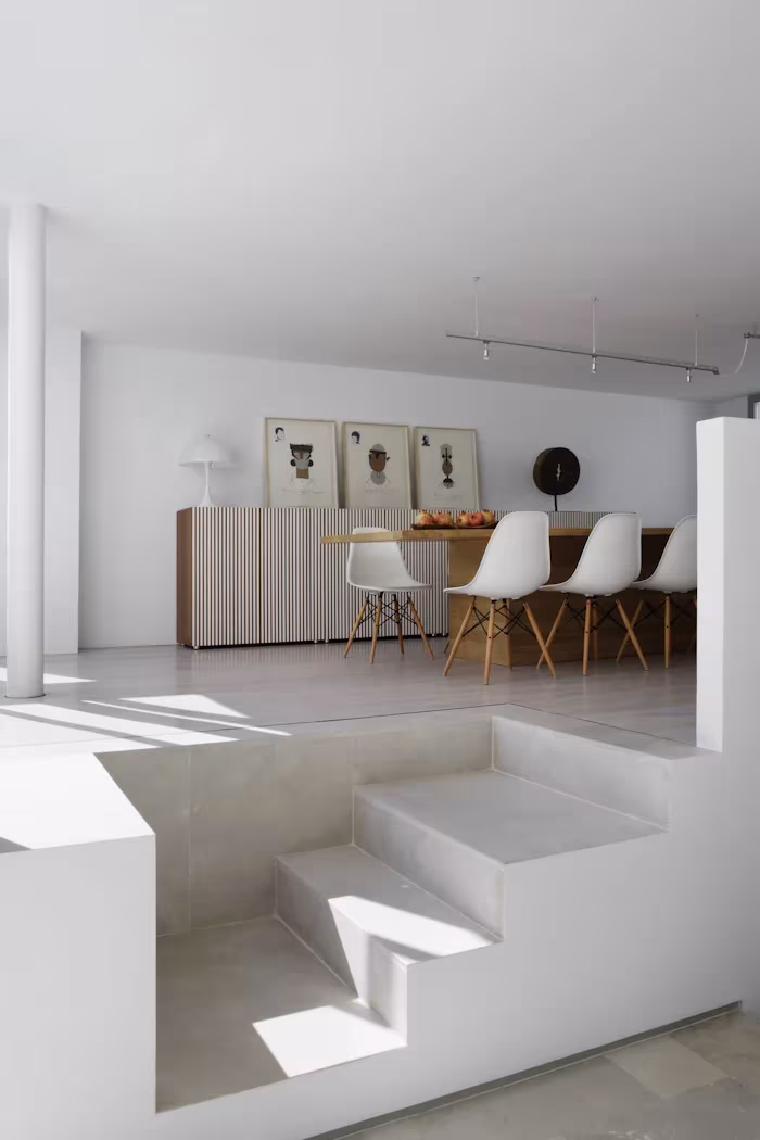 _X5C4752 Comedor elevado sobre una tarima de obra blanca con sillas Eames y un aparador de lamas en el Ático en U