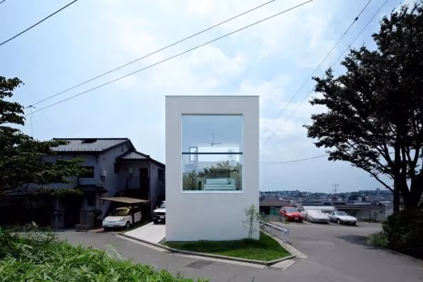 House in Hiyoshi de EANA en Yokohama: volumen blanco y estrecho con un gran ventanal junto a la calle