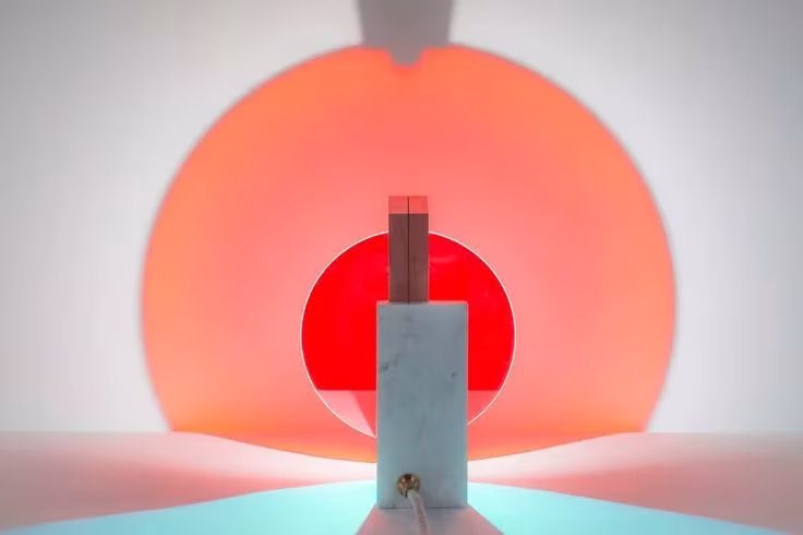 Lámpara Day & Night de Éléonore Delisse: pieza de mármol ante un halo de luz roja y naranja