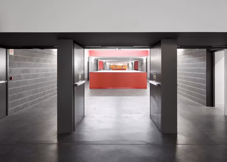 b1141038 Pasillo de la escuela Braamcamp Freire con muros de bloque gris y un mostrador rojo al fondo