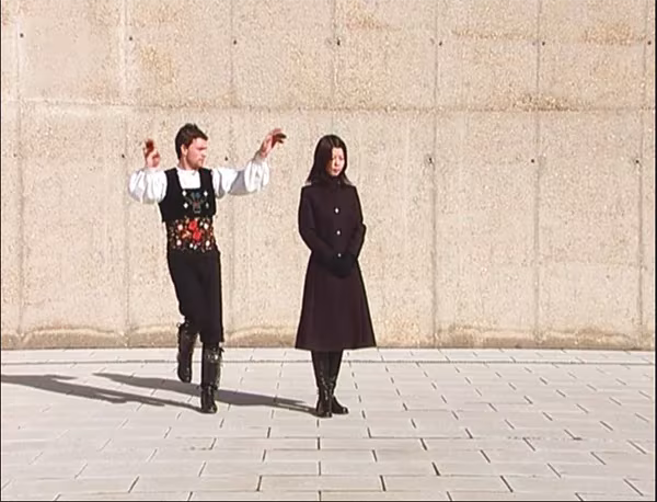 Obra de la colección Alicia Aza: hombre con traje tradicional bailando junto a una mujer de negro ante un muro