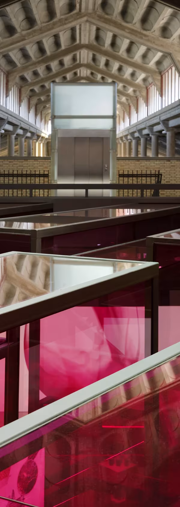 Bodegas Olarra de IA+B Arkitektura: vitrinas rojas bajo las bóvedas de madera de la nave hexagonal
