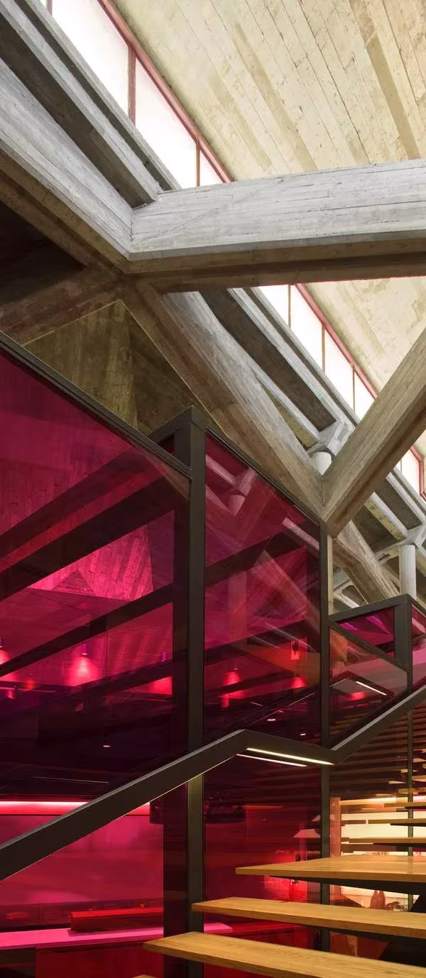 Bodegas Olarra: escalera con barandilla roja translúcida bajo la estructura de madera y lucernarios