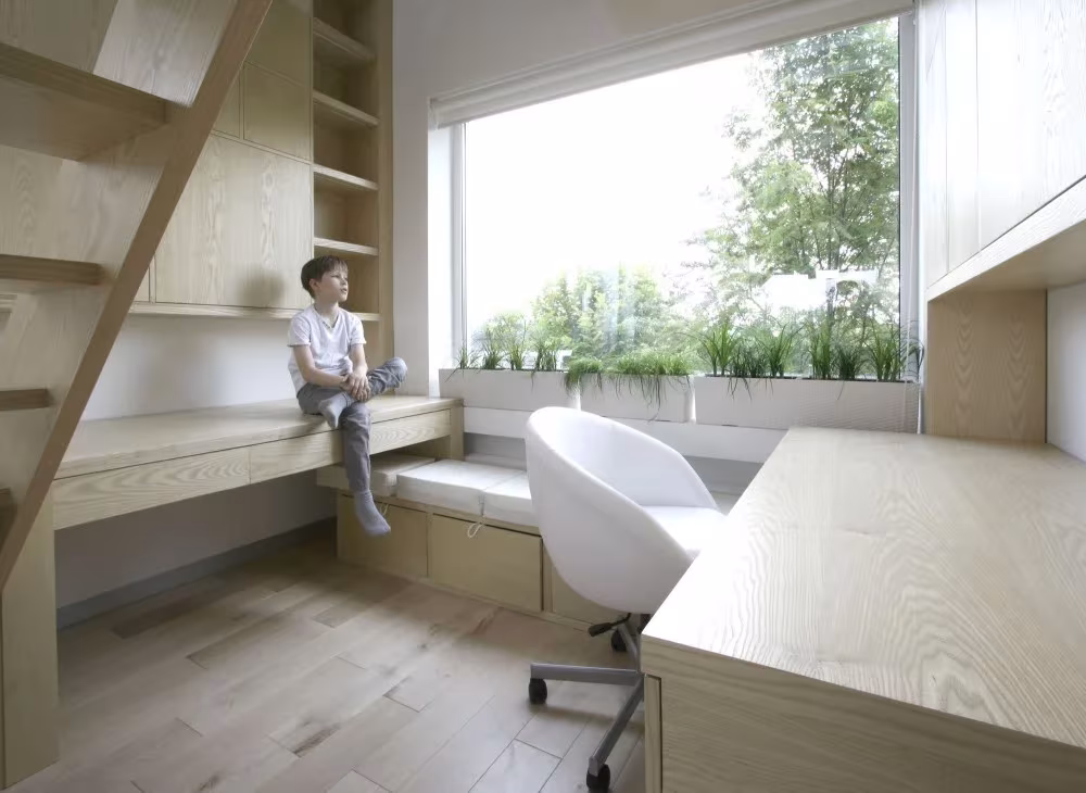 Zona de estudio de la residencia de Moscú: banco bajo el ventanal, escritorio de madera y silla blanca