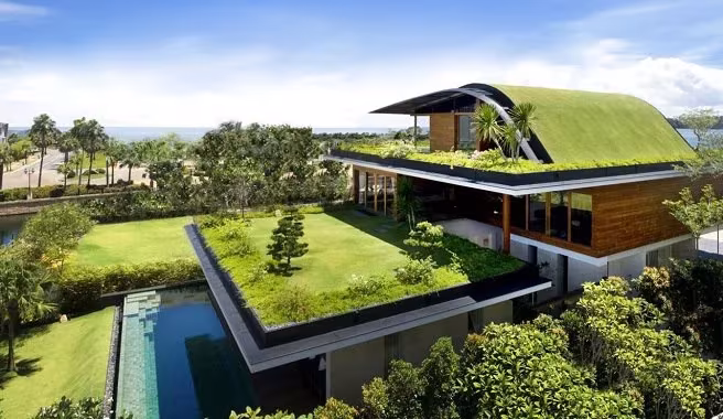 Meera Sky Garden House de Guz Architects en Singapur, cubiertas ajardinadas escalonadas junto a palmeras y agua