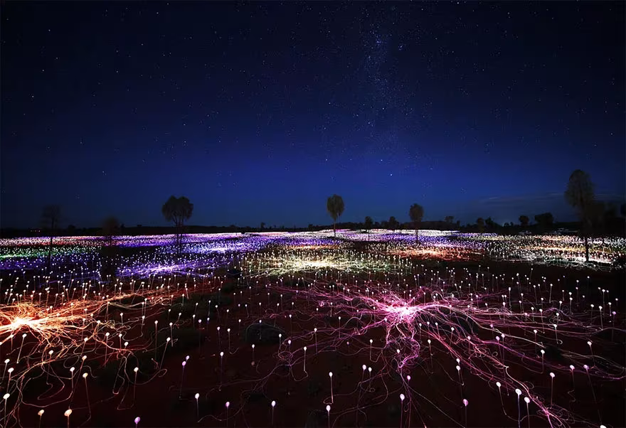Field of Light de Bruce Munro junto a Uluru: miles de tallos de luz de colores bajo un cielo estrellado
