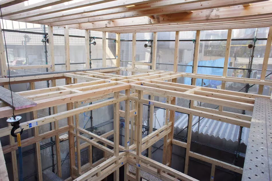 House T en obra: entramado de listones de madera y forjados en construcción vistos desde arriba
