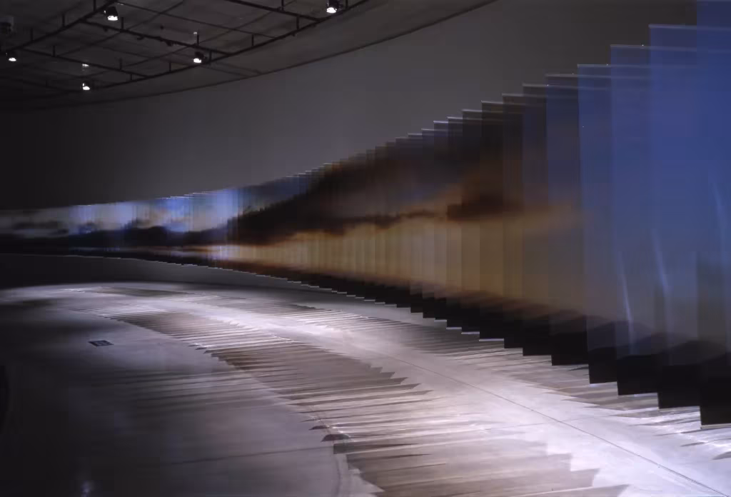 Layer Drawings de Nobuhiro Nakanishi: láminas acrílicas impresas en fila curva en una sala oscura