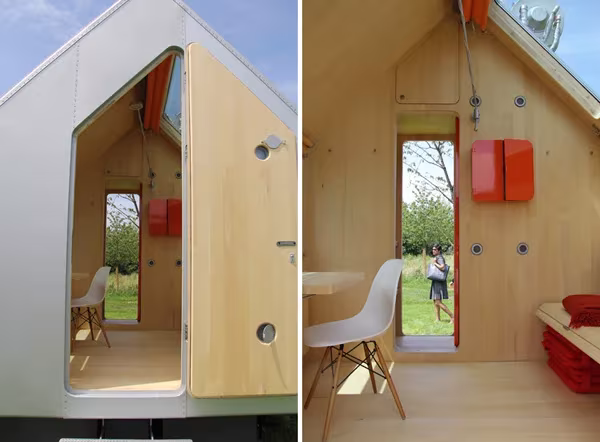 Puerta abierta de la Diogene y vista interior hacia el exterior, con silla blanca y armario naranja