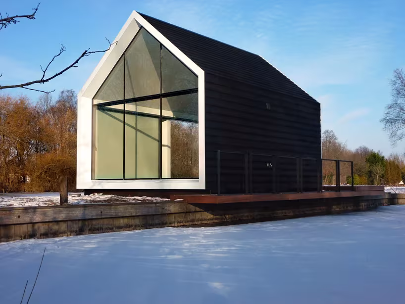 Hastial acristalado con marco blanco de la casita de 2by4 architects bajo un cielo azul invernal