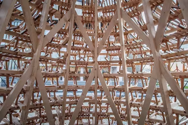 Entramado de trineos de madera clara que forma el interior del árbol de Navidad de Hello Wood