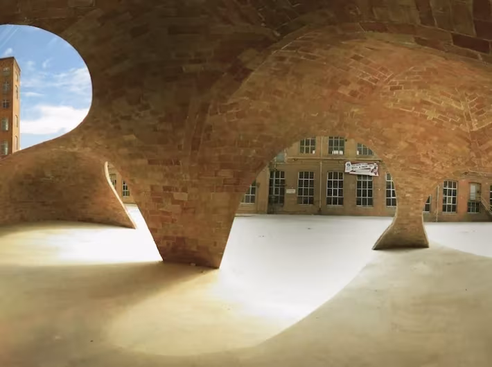 Interior vacío del pabellón Bricktopia de Map13, con bóvedas de ladrillo apoyadas en pies curvos