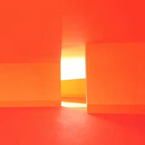 Juego de planos naranjas y luz cenital en un rincón interior de las Escuelas Josephine Baker