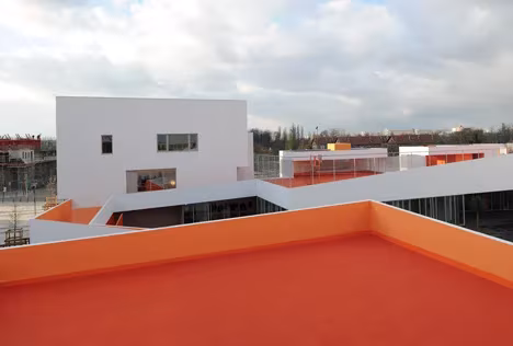 Terraza naranja de las Escuelas Josephine Baker con vistas a los volúmenes blancos del conjunto