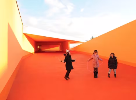 Niñas saltando a la comba en el patio naranja de las Escuelas Josephine Baker en La Courneuve