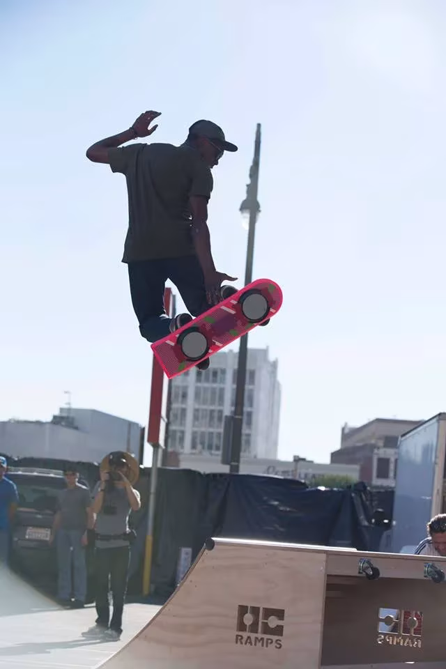 Patinador sobre el supuesto monopatín flotante HUVr rosa encima de una rampa de skate