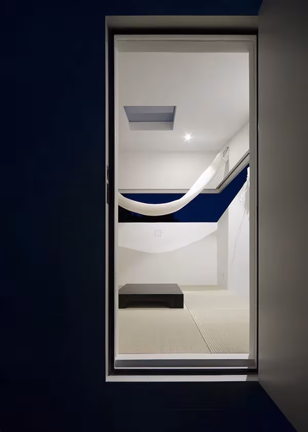 Puerta abierta de Paco de Jo Nagasaka mostrando el interior blanco con hamaca y tatami