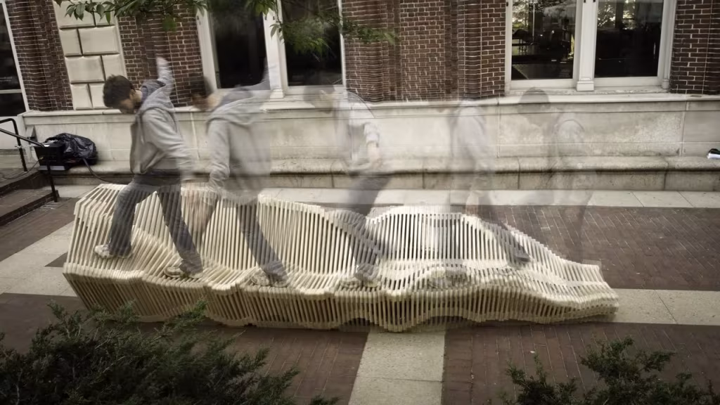 Persona en movimiento caminando sobre el banco Polimórfica junto a un edificio de ladrillo