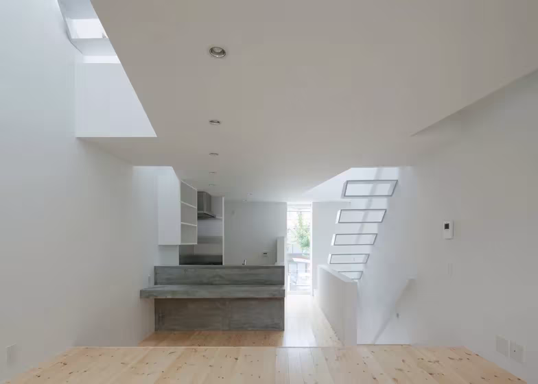 Planta de la cocina de la Casa Tamatsu con encimera de hormigón y escalera calada al fondo