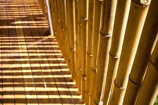Pasillo de la Casa Flotante con celosía de cañas de bambú que proyecta franjas de luz sobre el suelo de madera