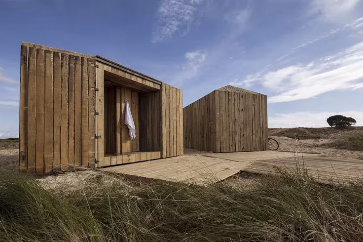 Cabañas en el río de Manuel Aires Mateus en Comporta: dos módulos de madera reciclada entre la hierba