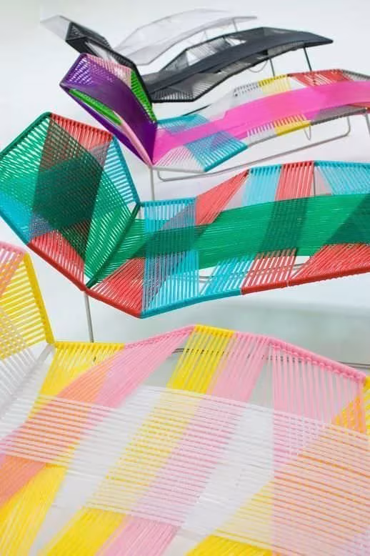 Tumbonas Tropicalia de Moroso apiladas, con tramas de cordón en rosa, verde, amarillo y lila
