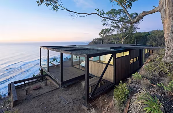 Casa Till de WMR Arquitectos sobre el acantilado de la costa chilena, con estructura oscura y vistas al mar