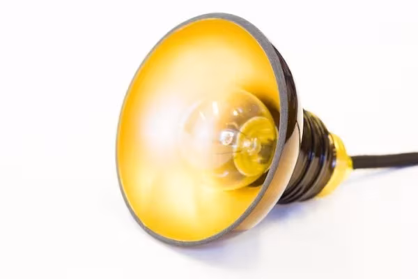 Interior dorado de la pantalla de una lámpara Utrem Lux con la bombilla encendida