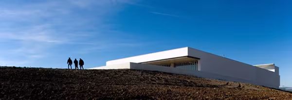 Visitantes en la cubierta de la Adega Maior de Álvaro Siza, que se recorta blanca sobre la colina