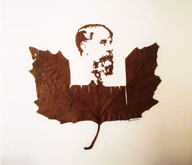 Hoja seca recortada por Omid Asadi con el retrato de un hombre con bigote calado en su parte superior