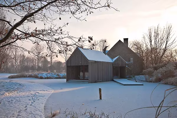 El Refugio de Wim Goes en invierno, con la casa de madera y el jardín cubiertos de nieve